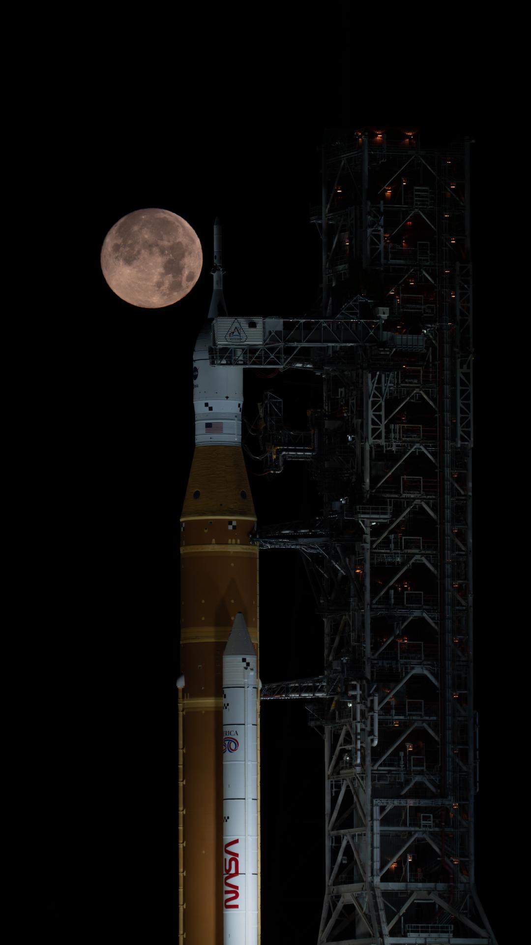 A full Moon is seen shining over NASA’s SLS (Space Launch System) and Orion spacecraft, atop the mobile launcher in the early hours of February 1, 2026. The rocket is currently at Launch Pad 39B at NASA’s Kennedy Space Center in Florida, as teams are preparing for a wet dress rehearsal to practice timelines and procedures for the launch of Artemis II.